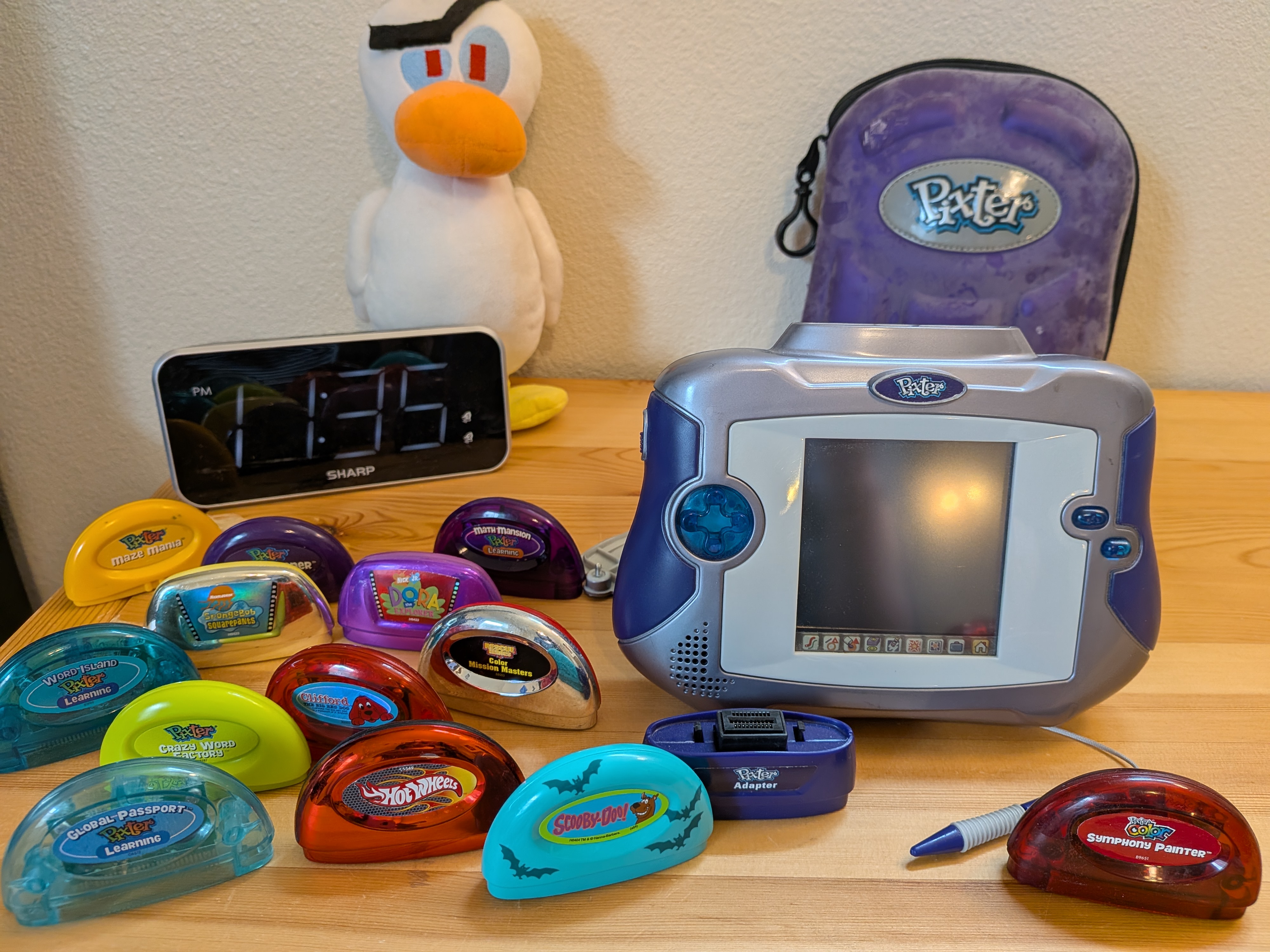 Image of a Mattel Pixter Multi-Media System, a case, and about a dozen game cartridges.